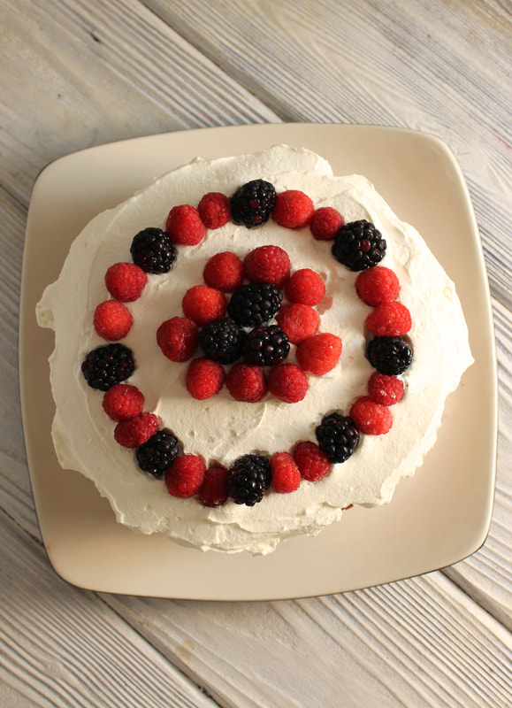 Berries and Cream Layer Cake with berries on top