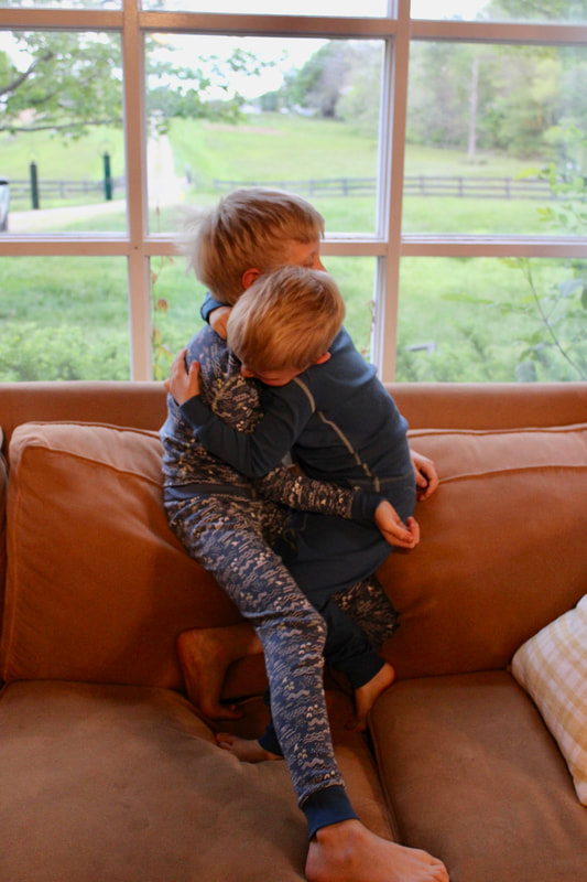 Brothers hugging while wearing pact pajamas