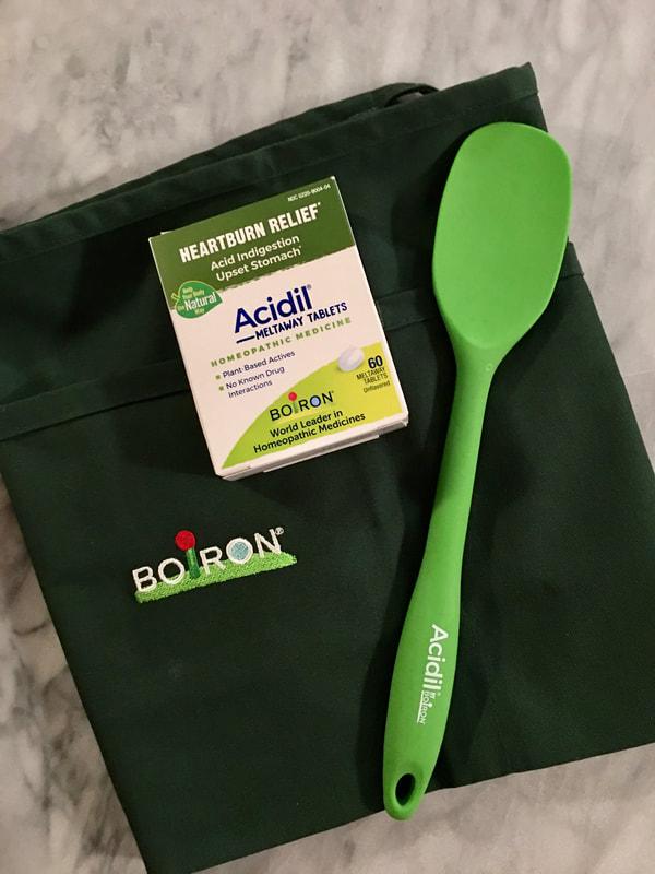 Acidil bundle, which includes a box of Acidil Meltaway Tablets (60 tablets), a branded Boiron apron, and a branded Acidil silicone spoon. 