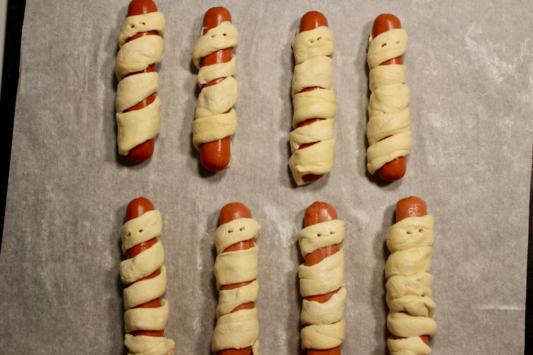 Dough wrapped mummy dogs ready to go in the oven