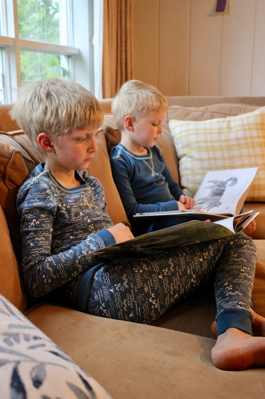 Boys reading while wearing Pact organic pajamas