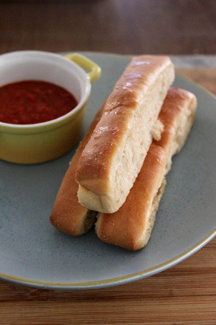 breadsticks on plate with marinara sauce