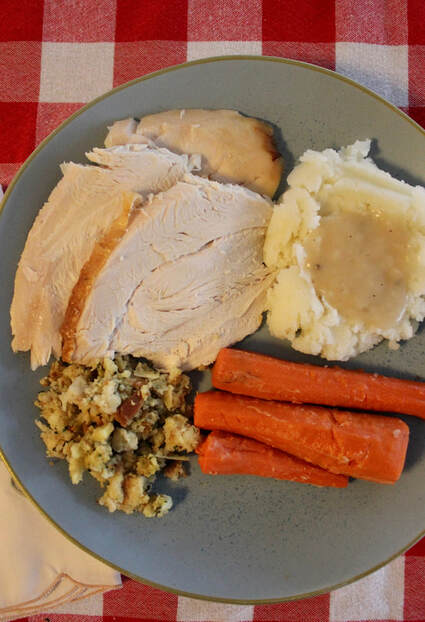 Turkey with mashed potatoes and gravy, stuffing, and glazed carrots